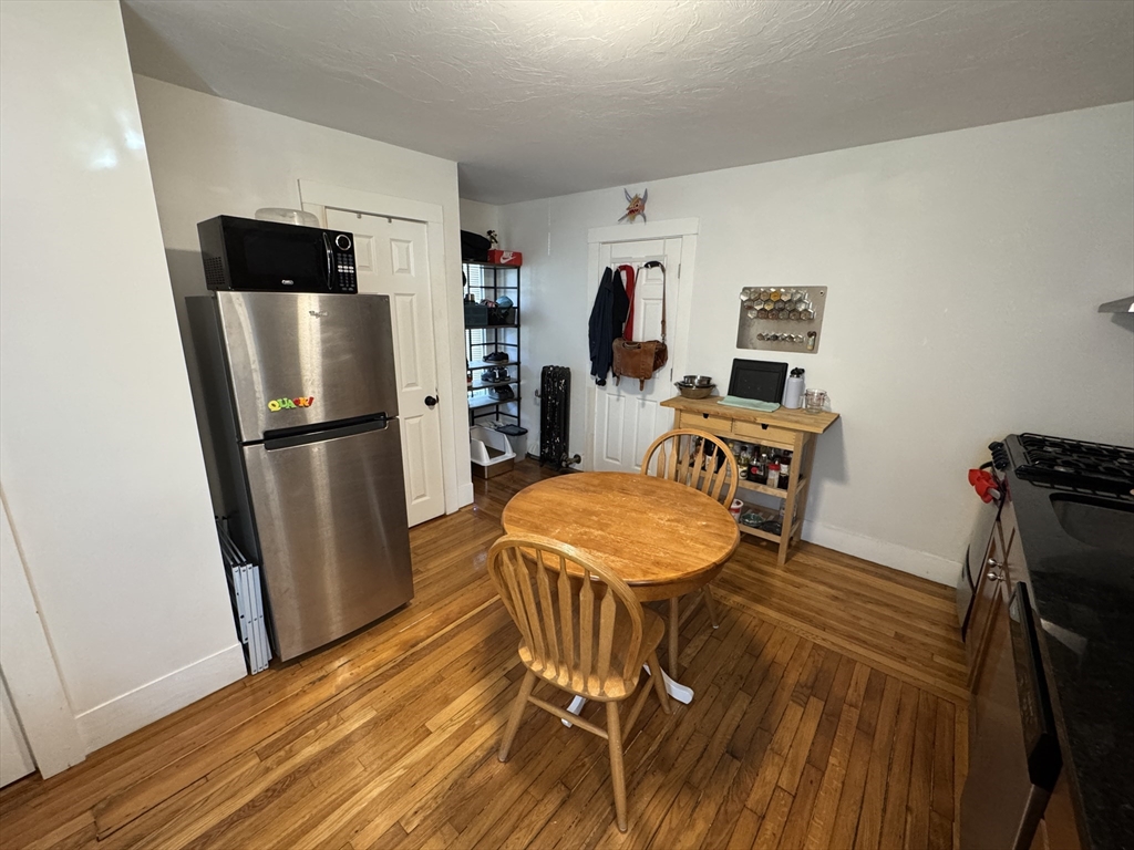 5 Blake Street, Unit 4 Cambridge, MA 02140 - Photo 7 of 14 a kitchen with stainless steel appliances a refrigerator a stove a sink and a dining table