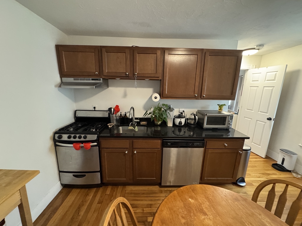 5 Blake Street, Unit 4 Cambridge, MA 02140 - Photo 8 of 14 a kitchen with stainless steel appliances granite countertop a stove and cabinets
