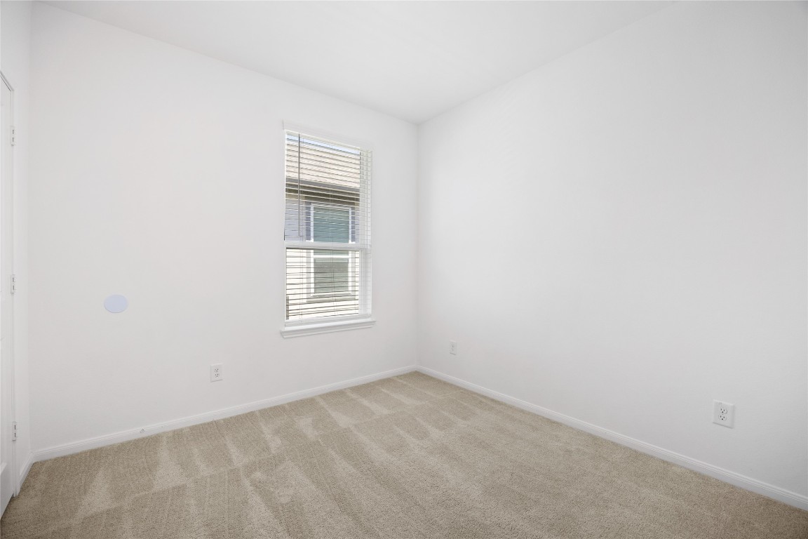 17907 Grain Auger Road Hockley, TX 77447 - Photo 17 of 24 bright, small room with white walls and a window allowing natural light. The carpeted floor adds warmth, and the space is ideal for a cozy bedroom or home office.