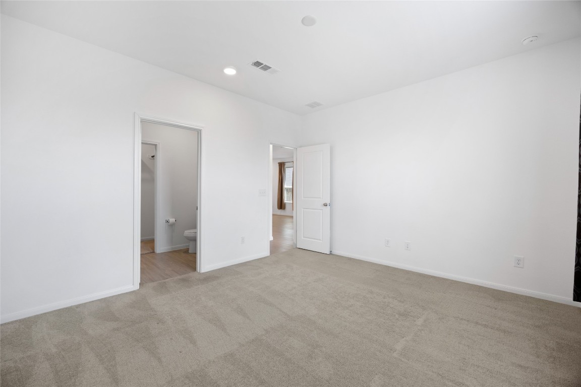 17907 Grain Auger Road Hockley, TX 77447 - Photo 20 of 24 neutral carpet and white walls, creating a bright, open space. It includes a door leading to a bathroom and another to the hallway, offering convenience and accessibility.