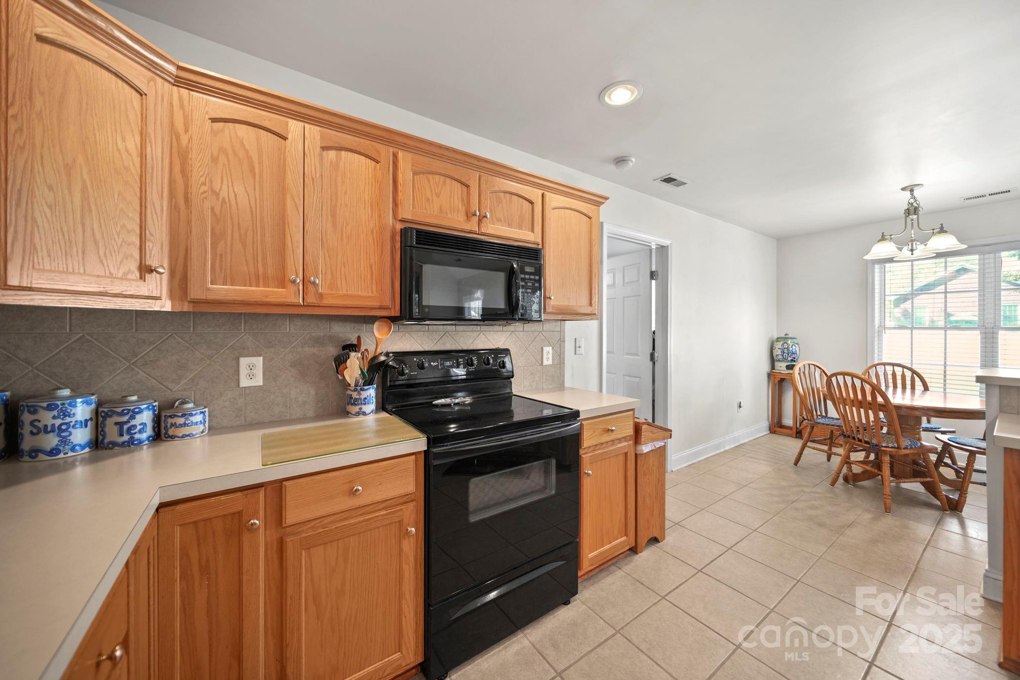 209 Lagoda Drive Locust, NC 28097 - Photo 17 of 43 a kitchen with stainless steel appliances granite countertop a stove top oven a sink dishwasher and a refrigerator with wooden cabinets