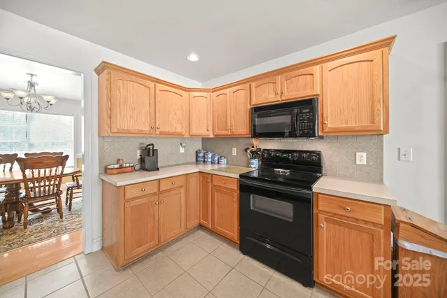 a kitchen with granite countertop a stove top oven microwave and cabinets