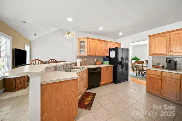 a kitchen with a sink a counter top space a large window and stainless steel appliances