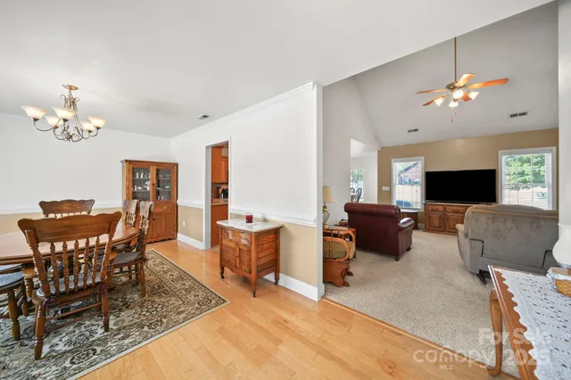 a living room with furniture a chandelier a mirror and a flat screen tv