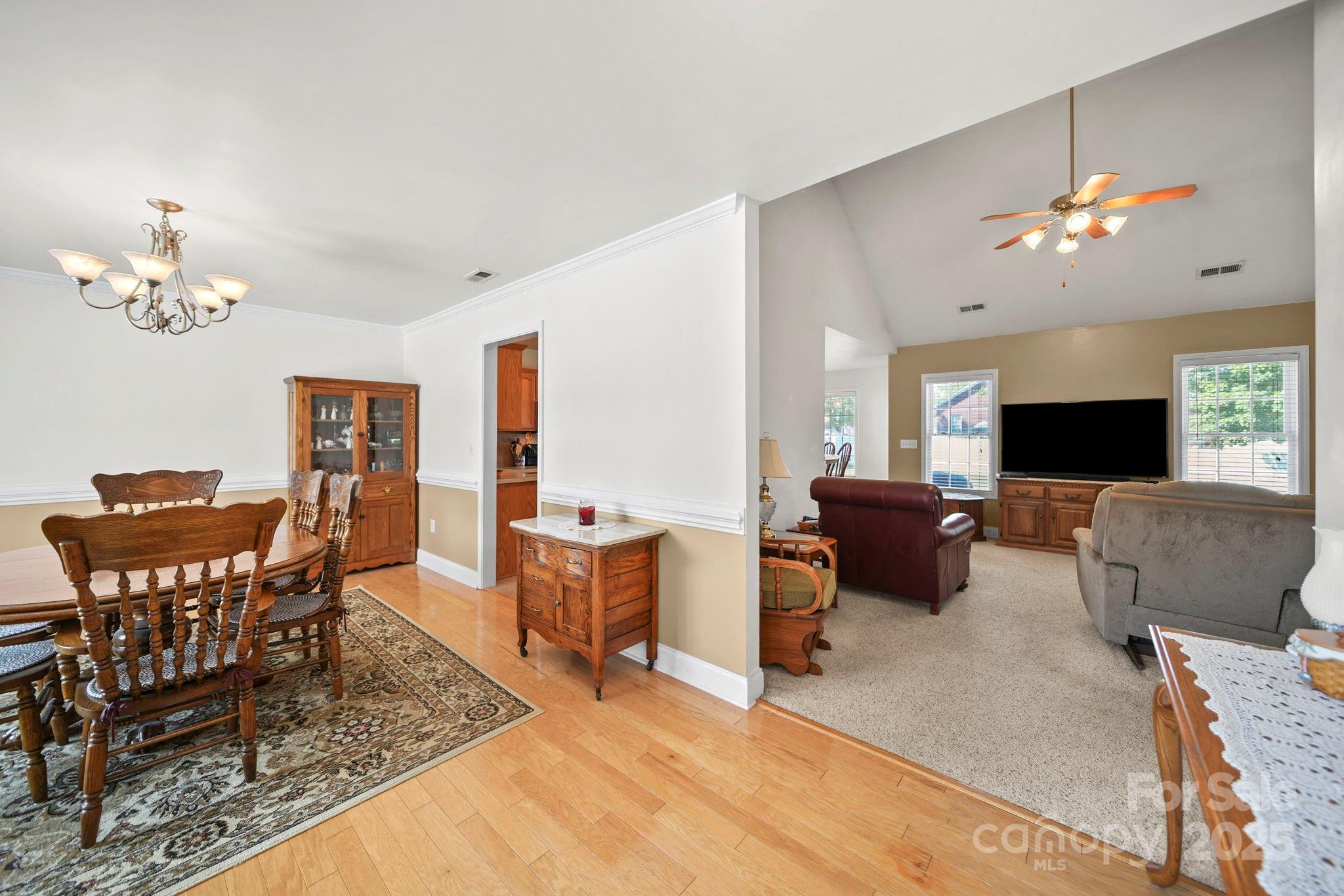 209 Lagoda Drive Locust, NC 28097 - Photo 10 of 43 a living room with furniture a chandelier a mirror and a flat screen tv