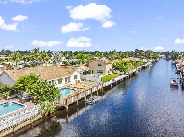 an aerial view of residential houses with outdoor space and river