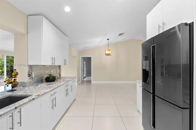 a kitchen with stainless steel appliances a refrigerator sink and cabinets