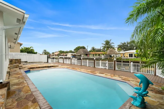 a view of a swimming pool with a lawn chairs under an umbrella