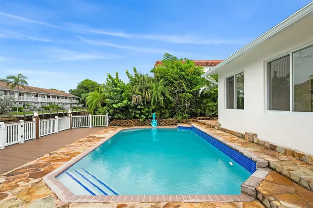 a swimming pool with trees in the background