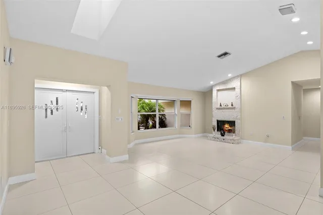 an empty room with windows and fireplace