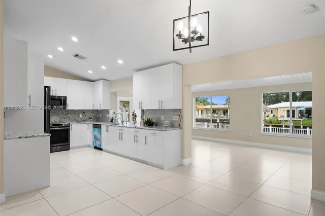 a large white kitchen with cabinets and stainless steel appliances