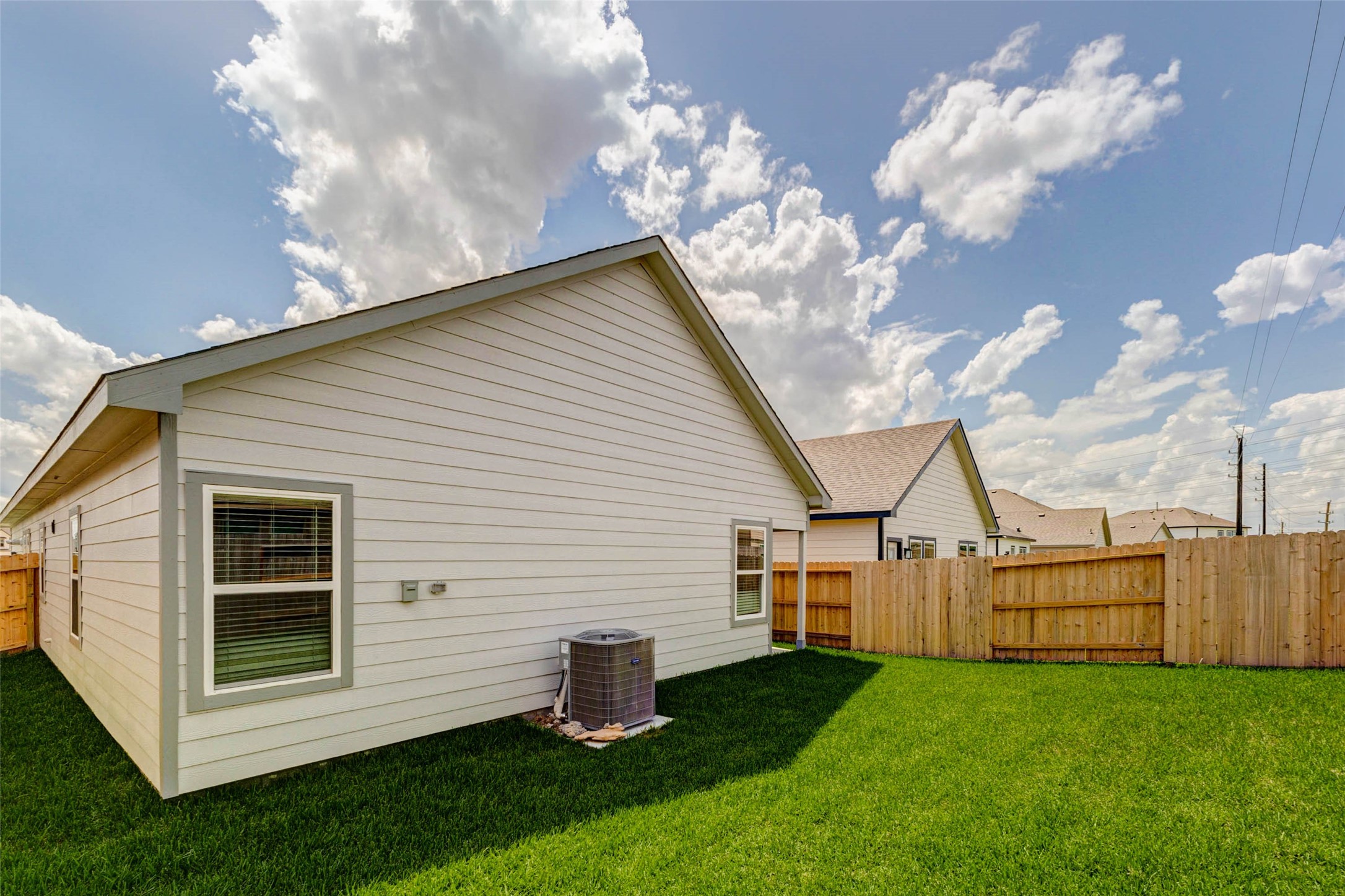 6463 Escondido Drive Rosharon, TX 77583 - Photo 29 of 30 Spacious backyard view with fresh grass, wood privacy fencing, side-yard access, and a clean rear exterior. The yard offers flexible outdoor space for everyday enjoyment, pets, play, or outdoor seating while remaining simple to maintain.