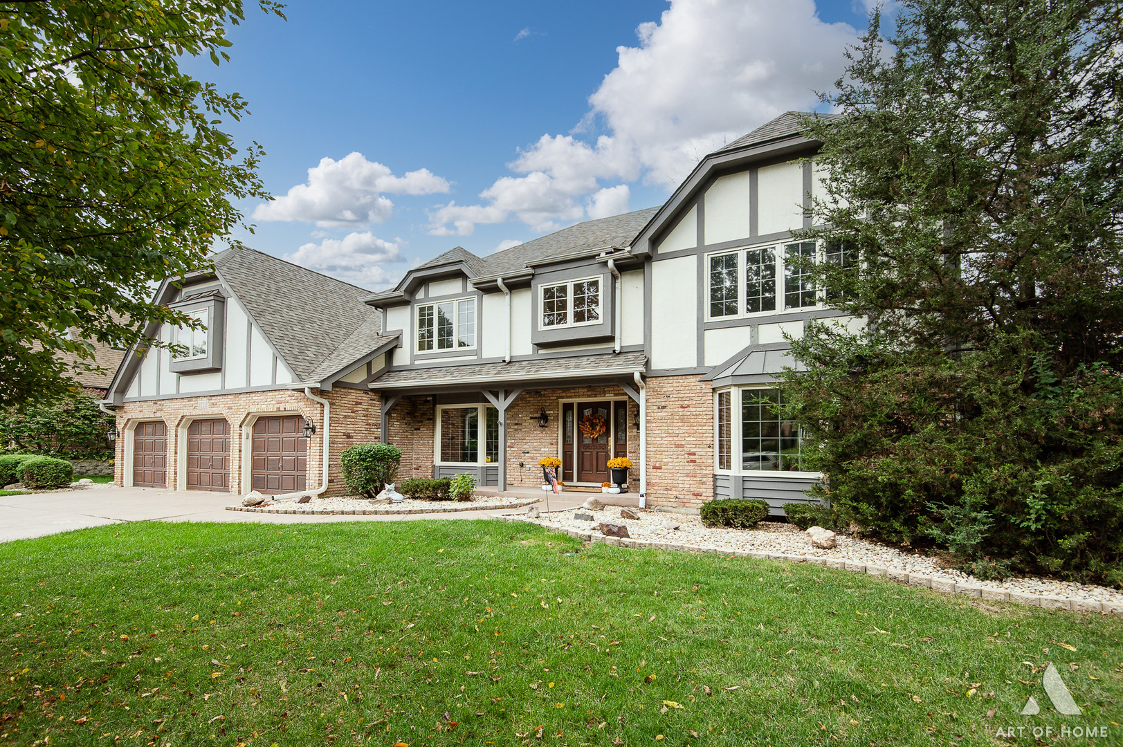 a front view of a house with a yard and trees