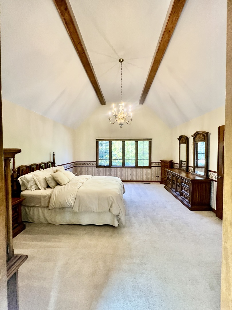 3112 Turnberry Road St. Charles, IL 60174 - Photo 39 of 77 a spacious bedroom with a bed a chandelier and large window
