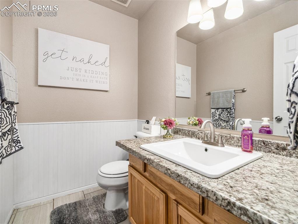 5044 Landmark Road Pueblo, CO 81008 - Photo 11 of 25 a bathroom with a granite countertop sink a toilet and a mirror