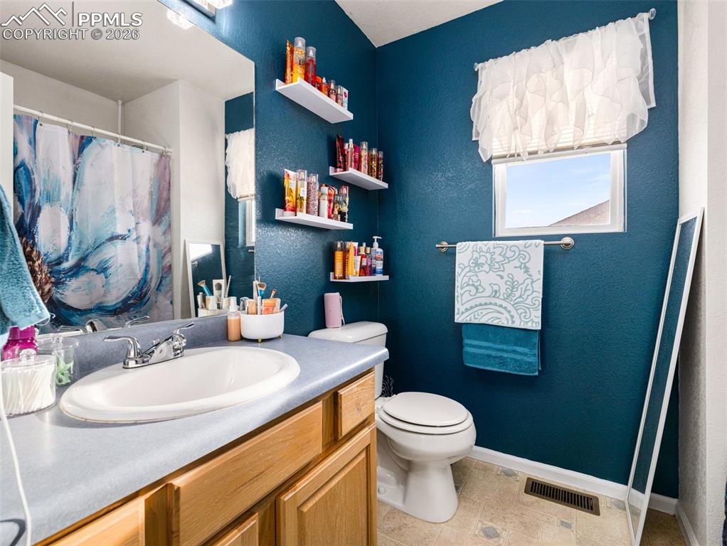 5044 Landmark Road Pueblo, CO 81008 - Photo 20 of 25 a bathroom with a toilet sink and mirror