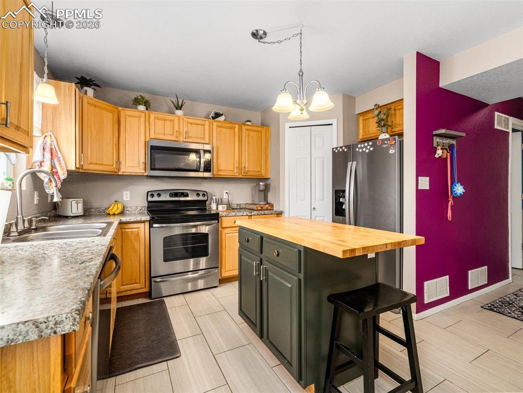 5044 Landmark Road Pueblo, CO 81008 - Photo 8 of 25 a kitchen with stainless steel appliances granite countertop a stove refrigerator sink and microwave