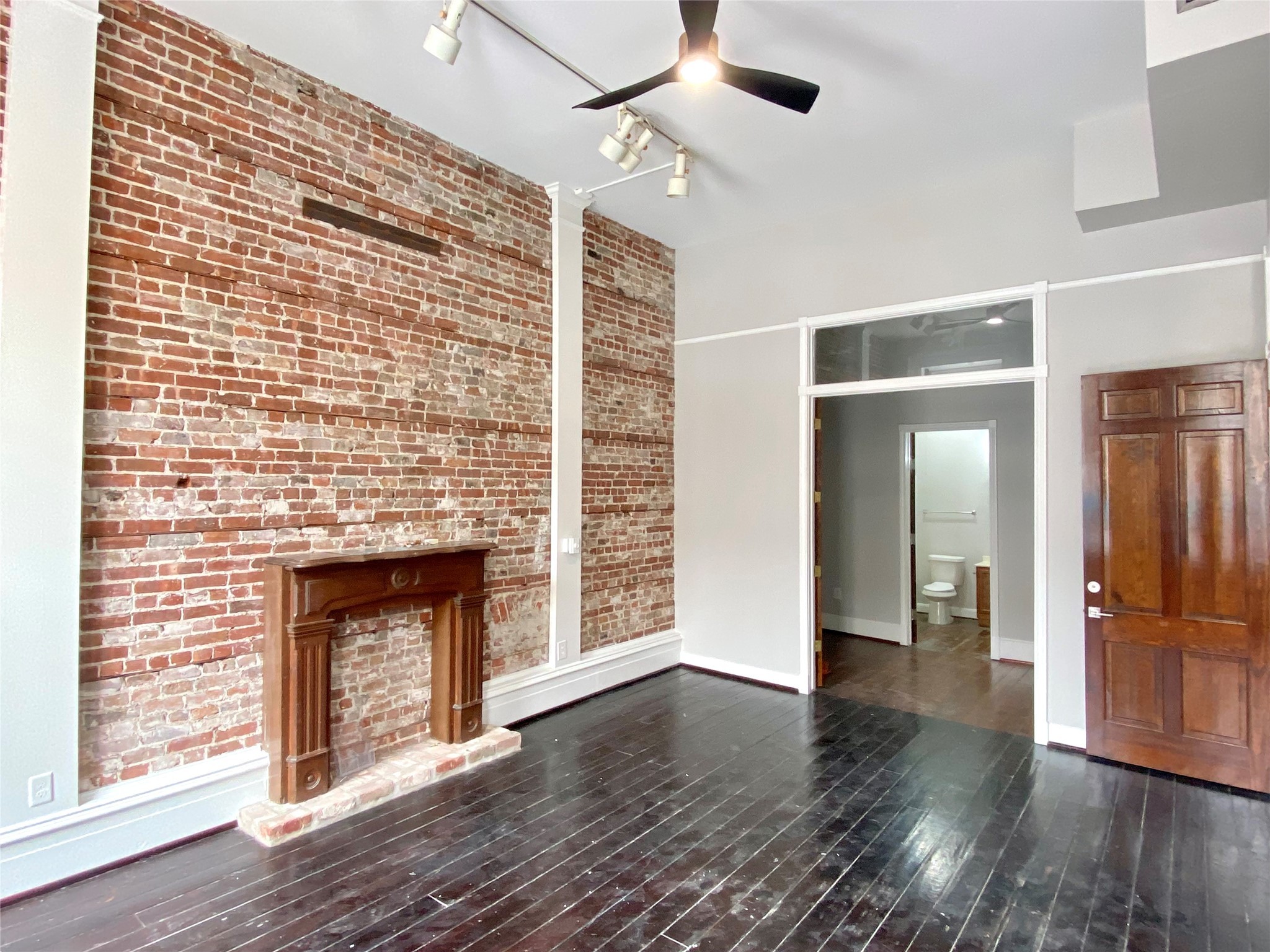 2319 The Strand, Unit 2A Galveston, TX 77550 - Photo 14 of 32 a view of an empty room with wooden floor fireplace and a window