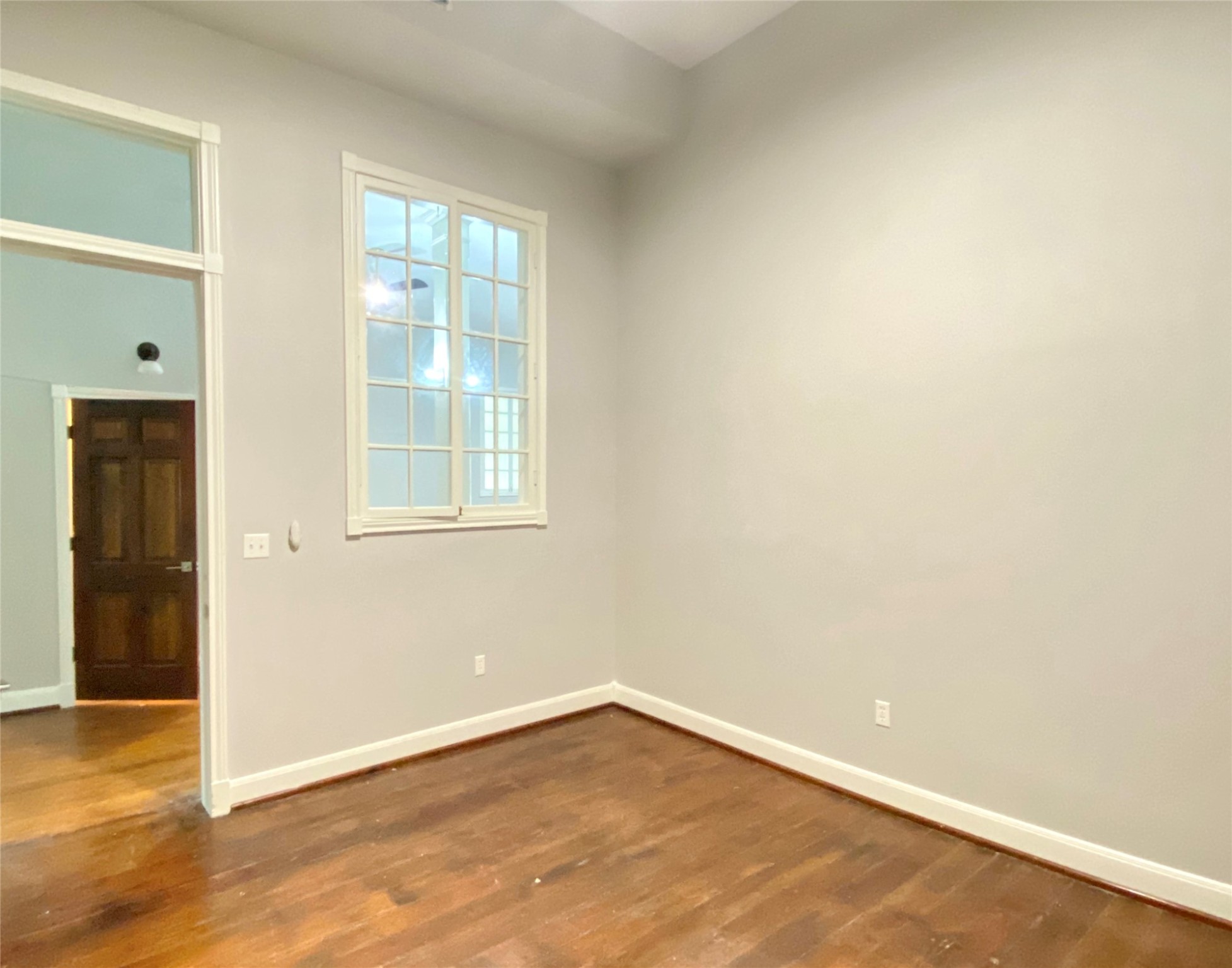 2319 The Strand, Unit 2A Galveston, TX 77550 - Photo 18 of 32 an empty room with wooden floor and windows