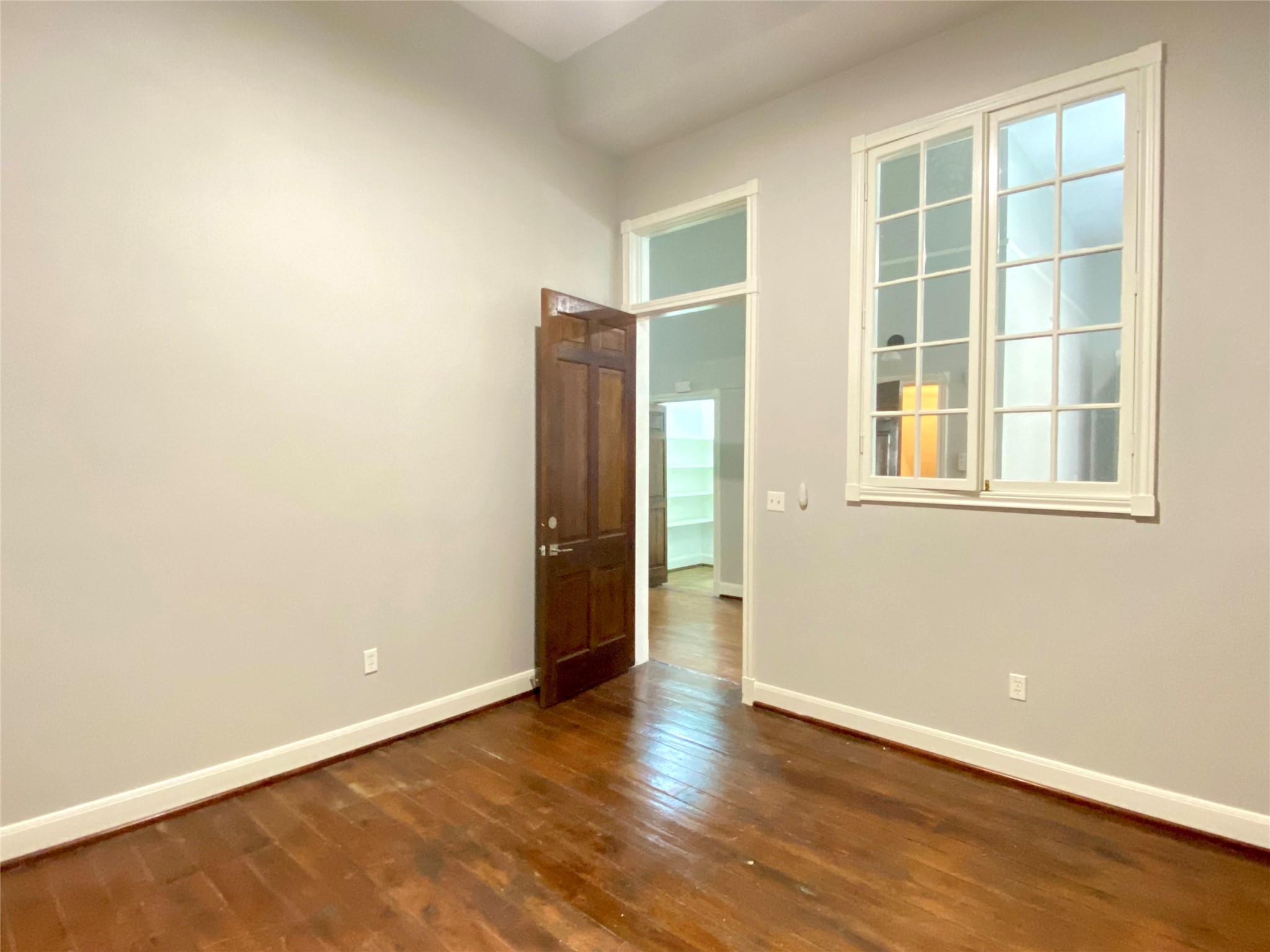 2319 The Strand, Unit 2A Galveston, TX 77550 - Photo 19 of 32 an empty room with wooden floor and windows