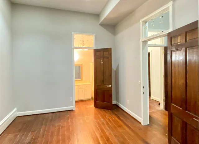an empty room with wooden floor and closet