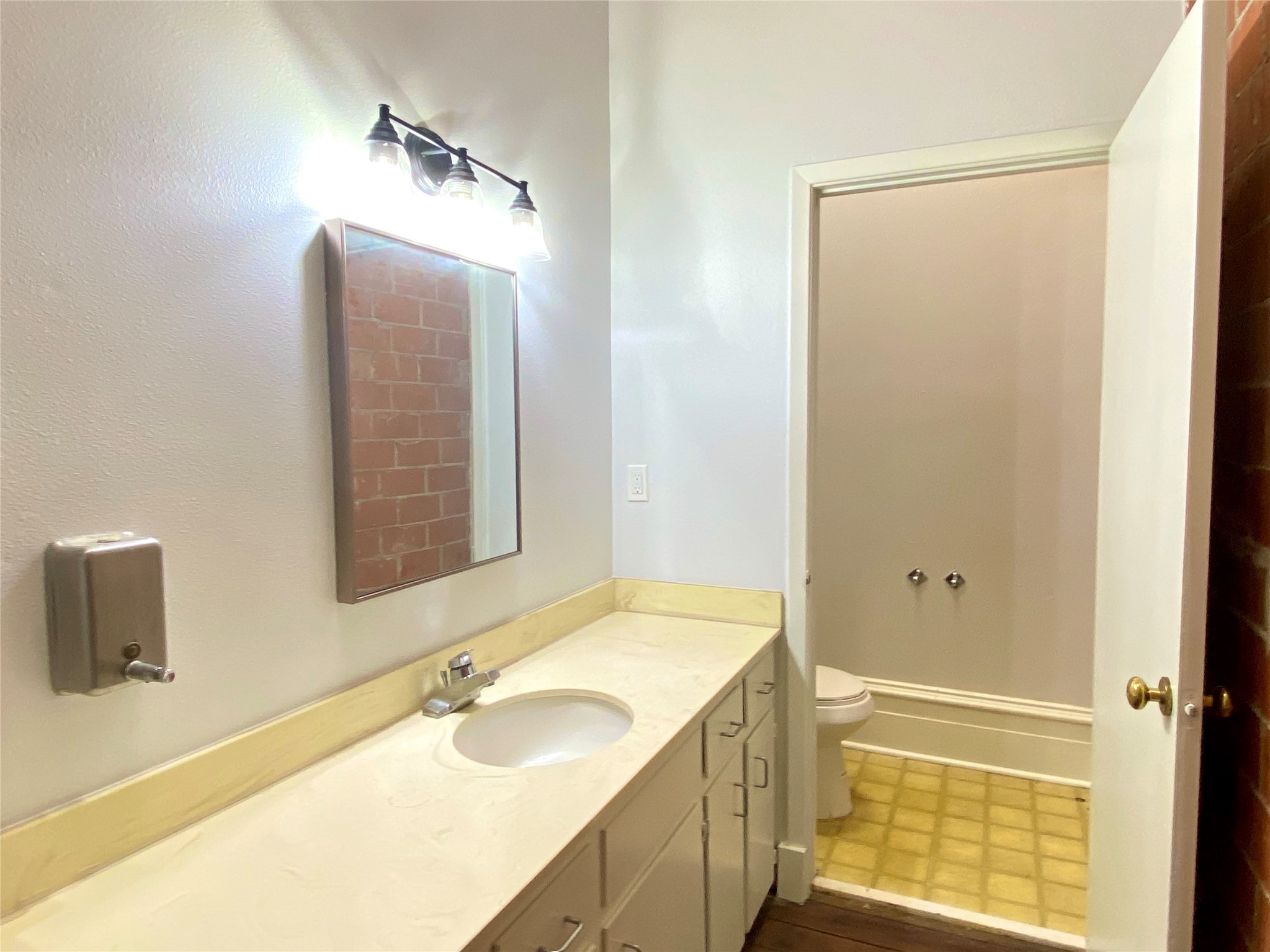 2319 The Strand, Unit 2A Galveston, TX 77550 - Photo 30 of 32 a bathroom with a granite countertop sink and a mirror