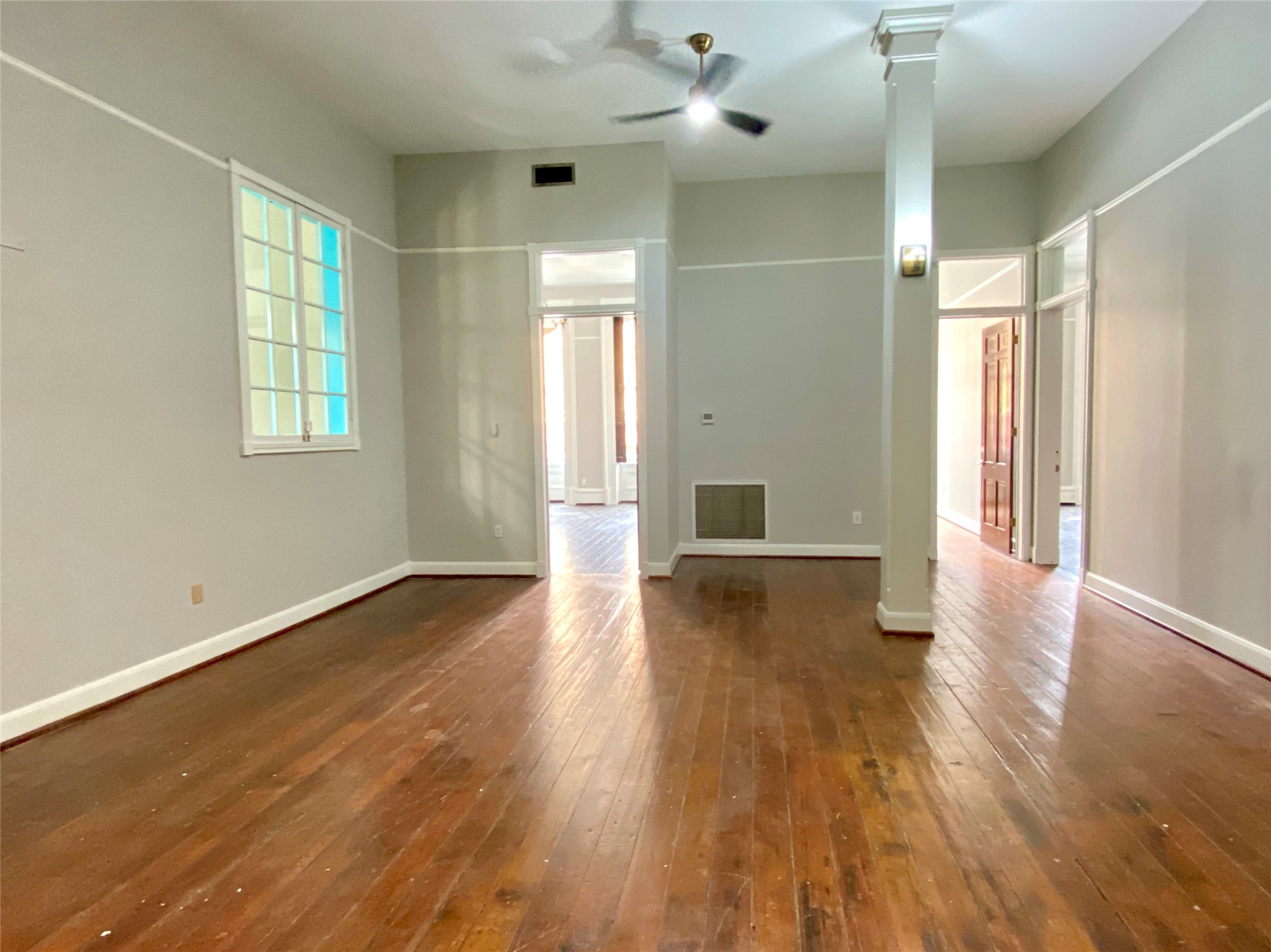 2319 The Strand, Unit 2A Galveston, TX 77550 - Photo 3 of 32 an empty room with wooden floor and windows