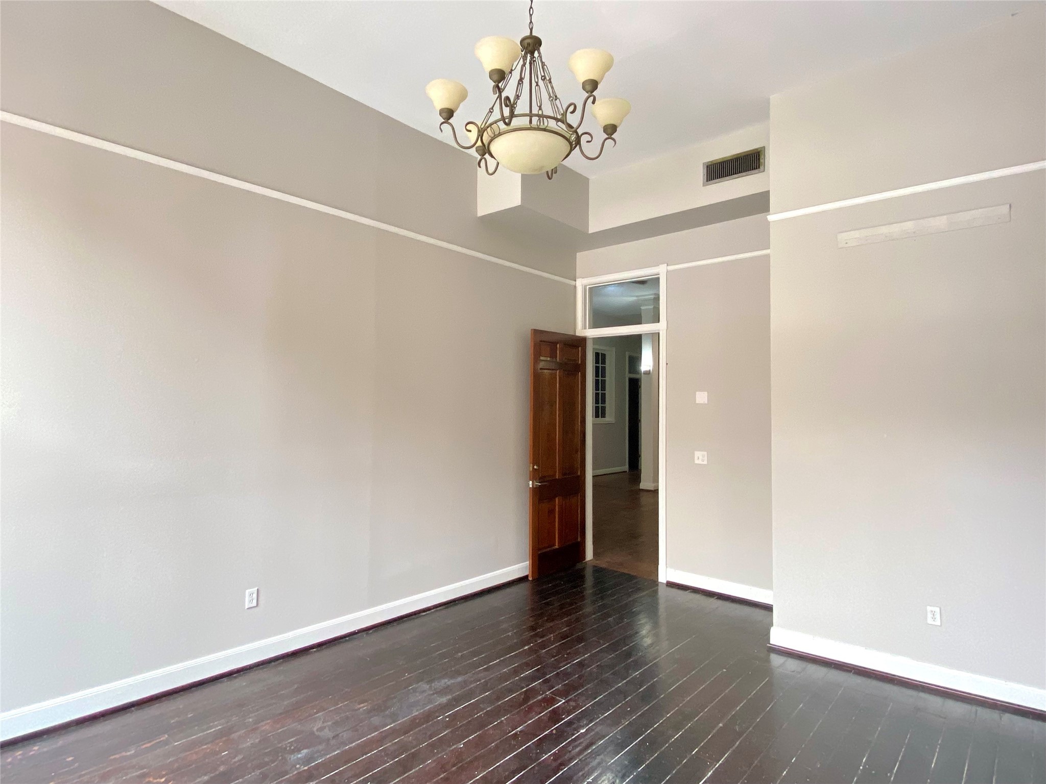2319 The Strand, Unit 2A Galveston, TX 77550 - Photo 8 of 32 a view of an empty room with wooden floor and chandelier