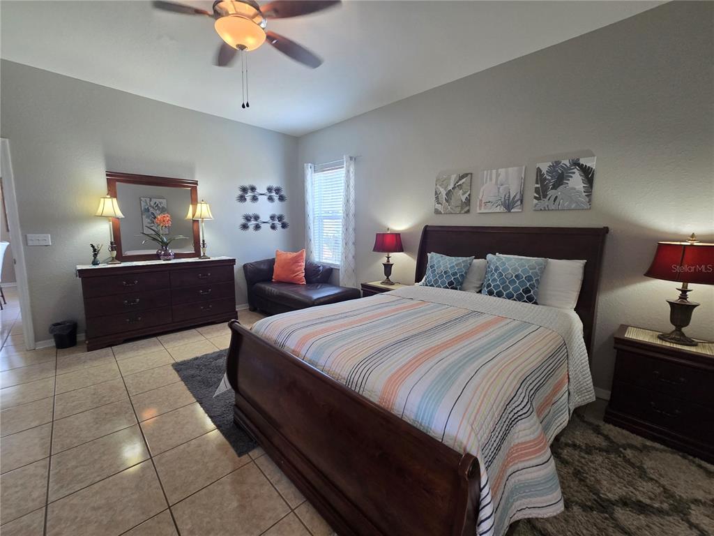 219 Cloverdale Road Winter Haven, FL 33884 - Photo 21 of 29 a bedroom with a large bed and a chandelier