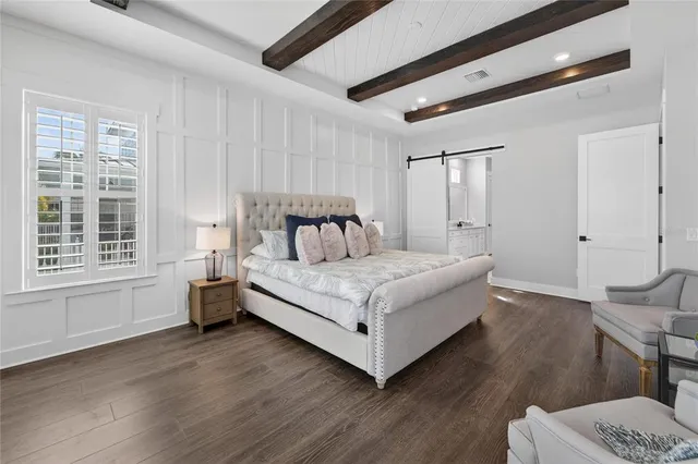 a bedroom with a bed chandelier and a window