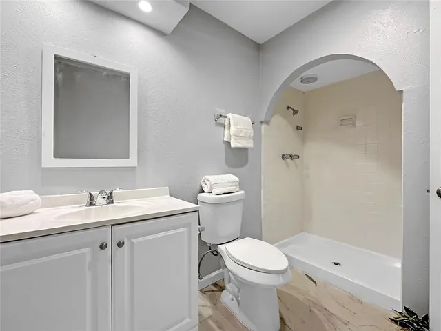 a bathroom with a sink a toilet and shower