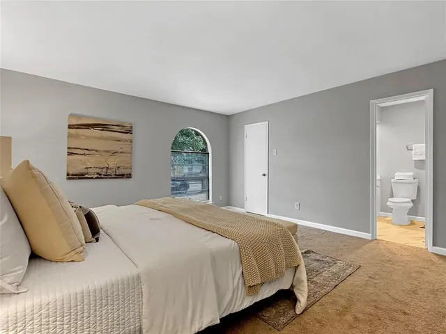 a bedroom with a large bed and a window