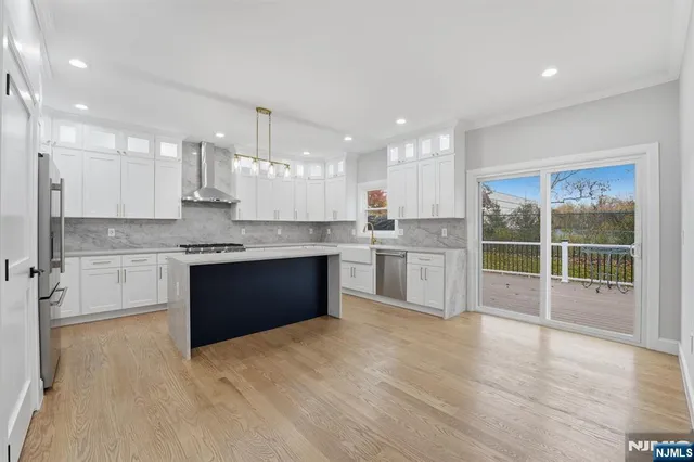 a kitchen with stainless steel appliances granite countertop a sink a refrigerator and a stove