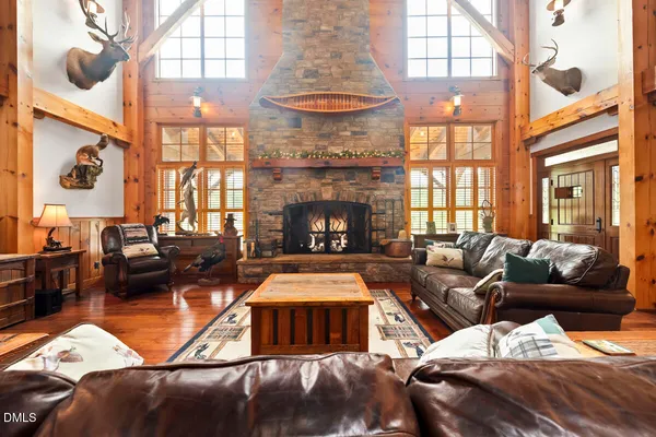an aerial view of a house with a yard and trees all around