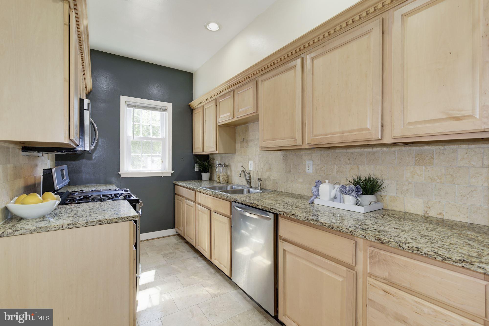 4200 River Road Northwest Washington, DC 20016 - Photo 9 of 30 a kitchen with granite countertop stainless steel appliances sink stove microwave and cabinets