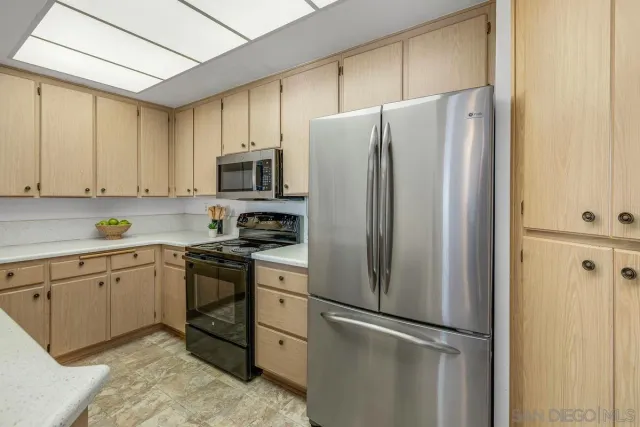 a kitchen with stainless steel appliances granite countertop a refrigerator stove a sink and dishwasher with cabinets