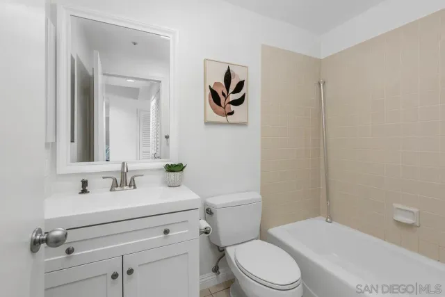 a bathroom with a toilet sink vanity and mirror
