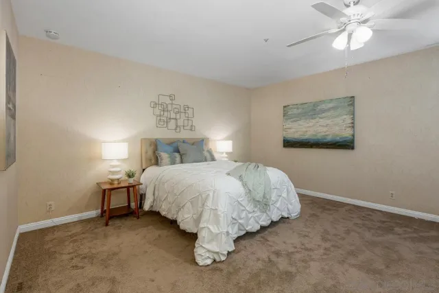 a bed sitting in a bedroom next to a lamp