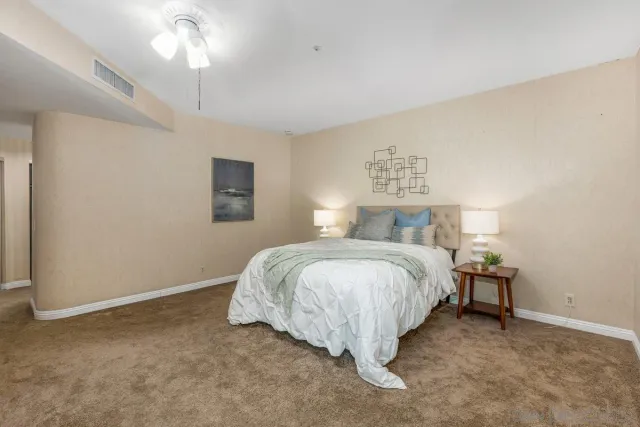 a spacious bedroom with a bed and a chandelier