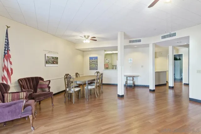 a living room with furniture and a dining table with wooden floor