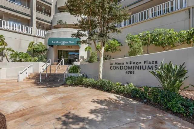 front view of a building with potted plants and a bench