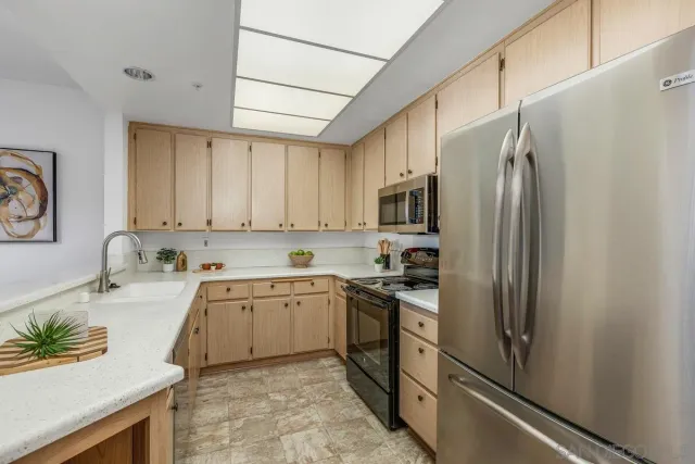 a kitchen with stainless steel appliances granite countertop a refrigerator sink and stove