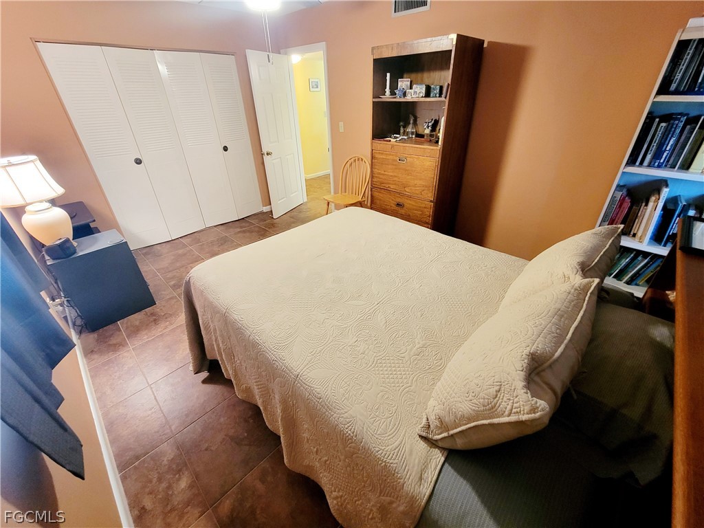 2206 East 6th Street Lehigh Acres, FL 33936 - Photo 19 of 30 a bedroom with a bed and a book shelf