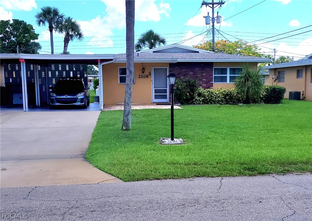 2206 East 6th Street Lehigh Acres, FL 33936 - Photo 2 of 30 a front view of a house with garden
