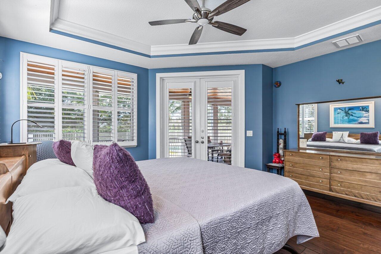 1802 Southwest Trailside Path Stuart, FL 34997 - Photo 14 of 57 a spacious bedroom with a large bed and a chandelier