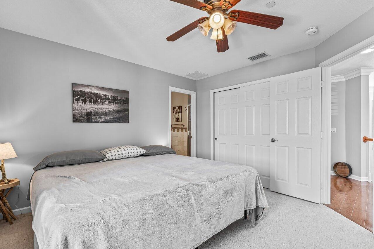 1802 Southwest Trailside Path Stuart, FL 34997 - Photo 23 of 57 a bedroom with a large bed and a chandelier