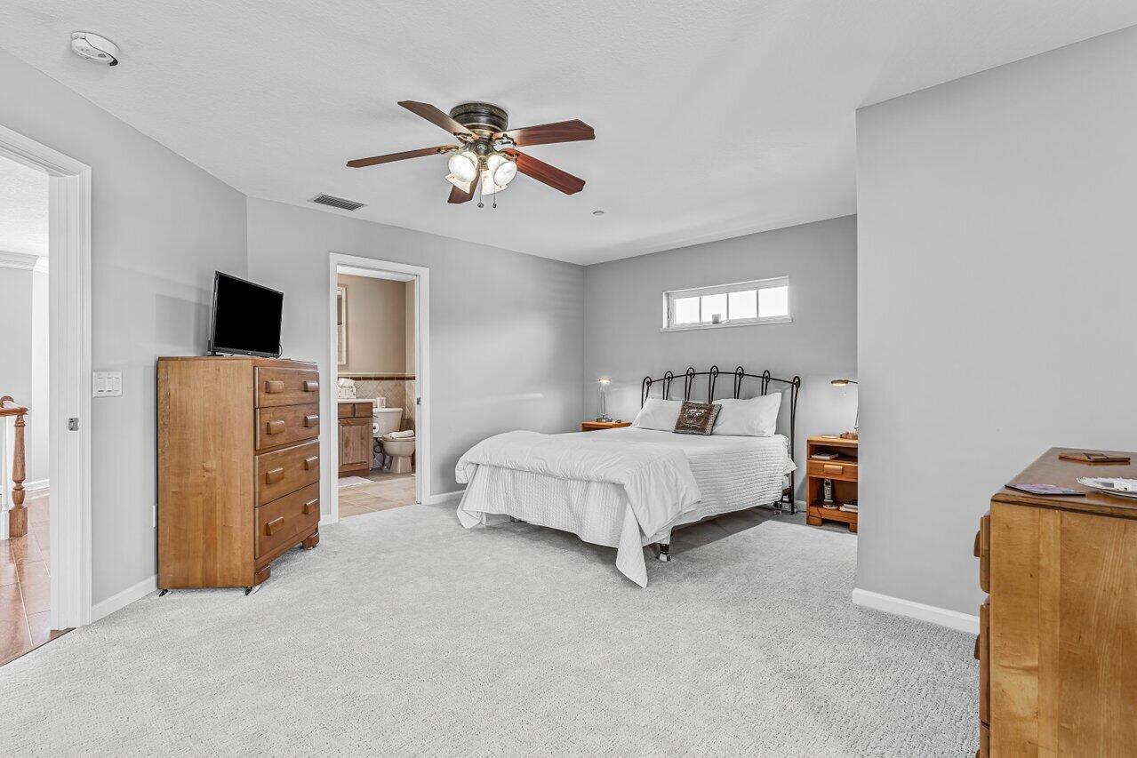 1802 Southwest Trailside Path Stuart, FL 34997 - Photo 25 of 57 a bedroom with a bed and a chandelier