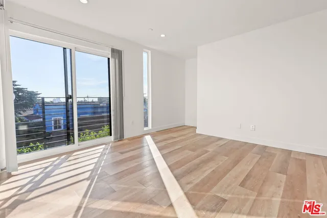 a view of a bedroom with floor to ceiling window and wooden floor