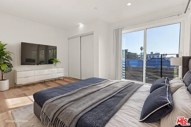 a bedroom with a balcony a bed and a flat screen television