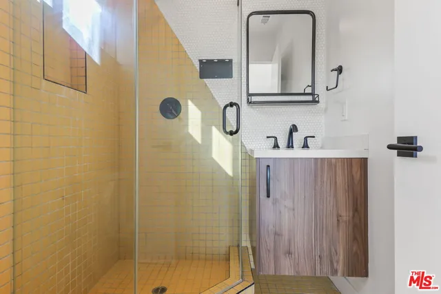 a bathroom with a sink a mirror and shower
